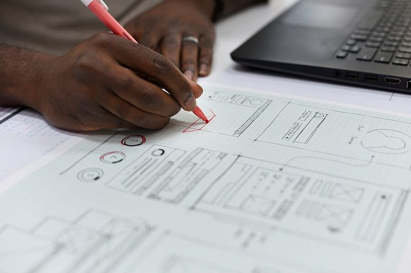 closeup-hand-writing-website-layout-paper-plan_53876-46262